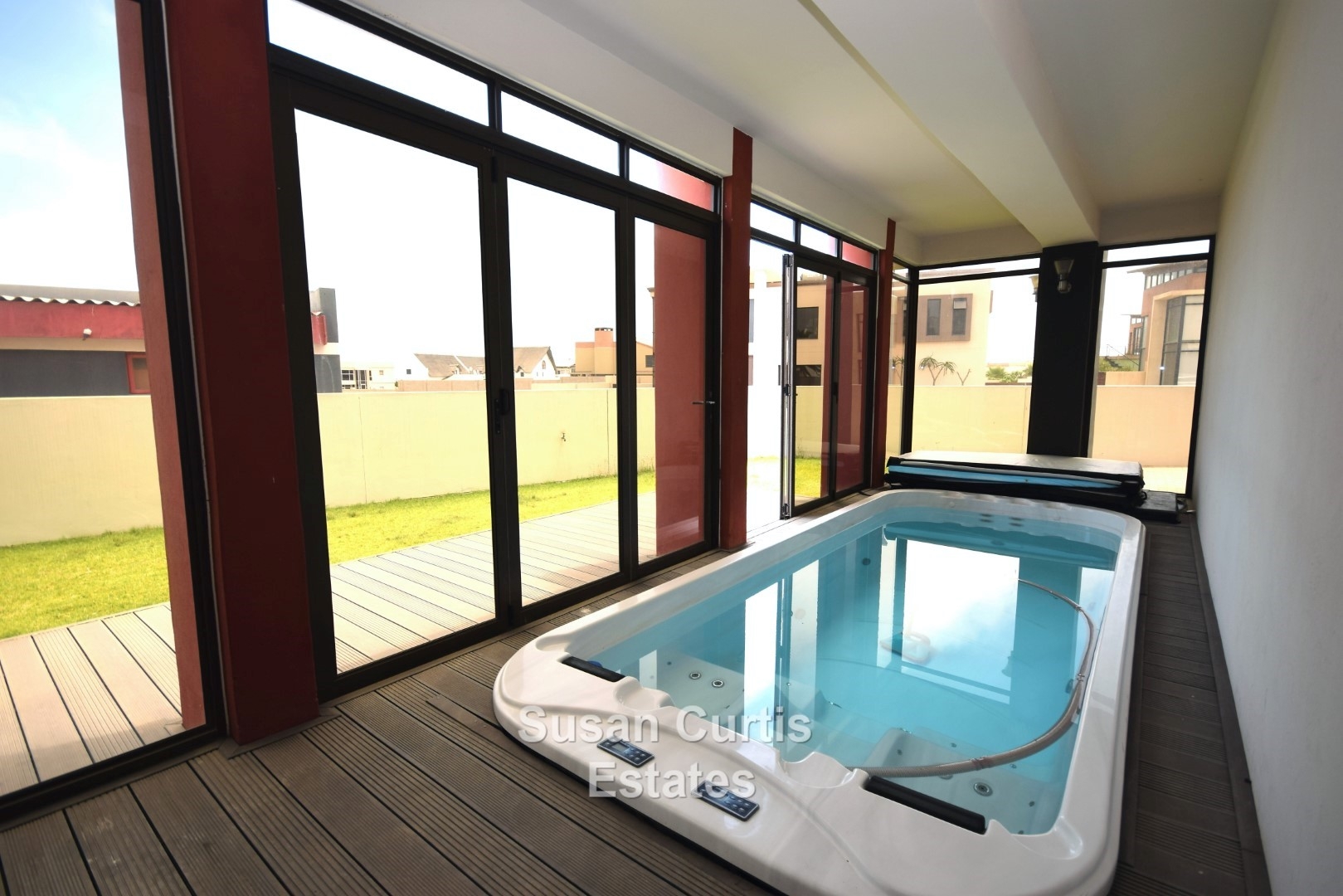 Pool/Jacuzzi room with stack doors towards undercover patio